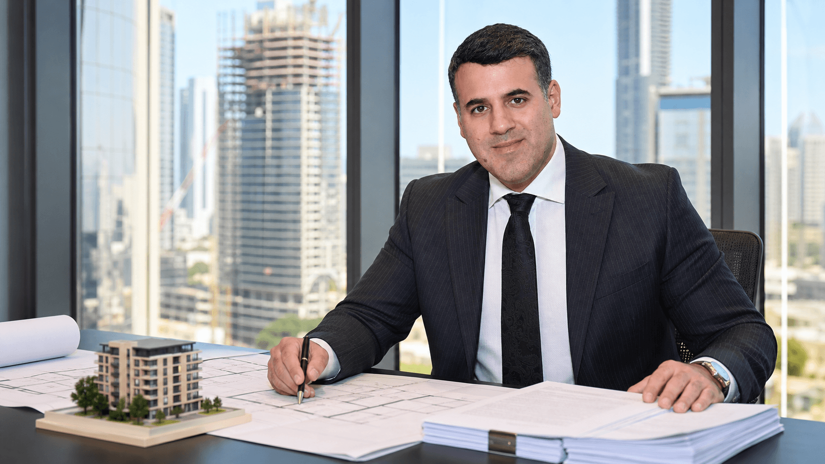 Asaf Arazi-Biton reviewing legal and planning documents for a real estate combination transaction