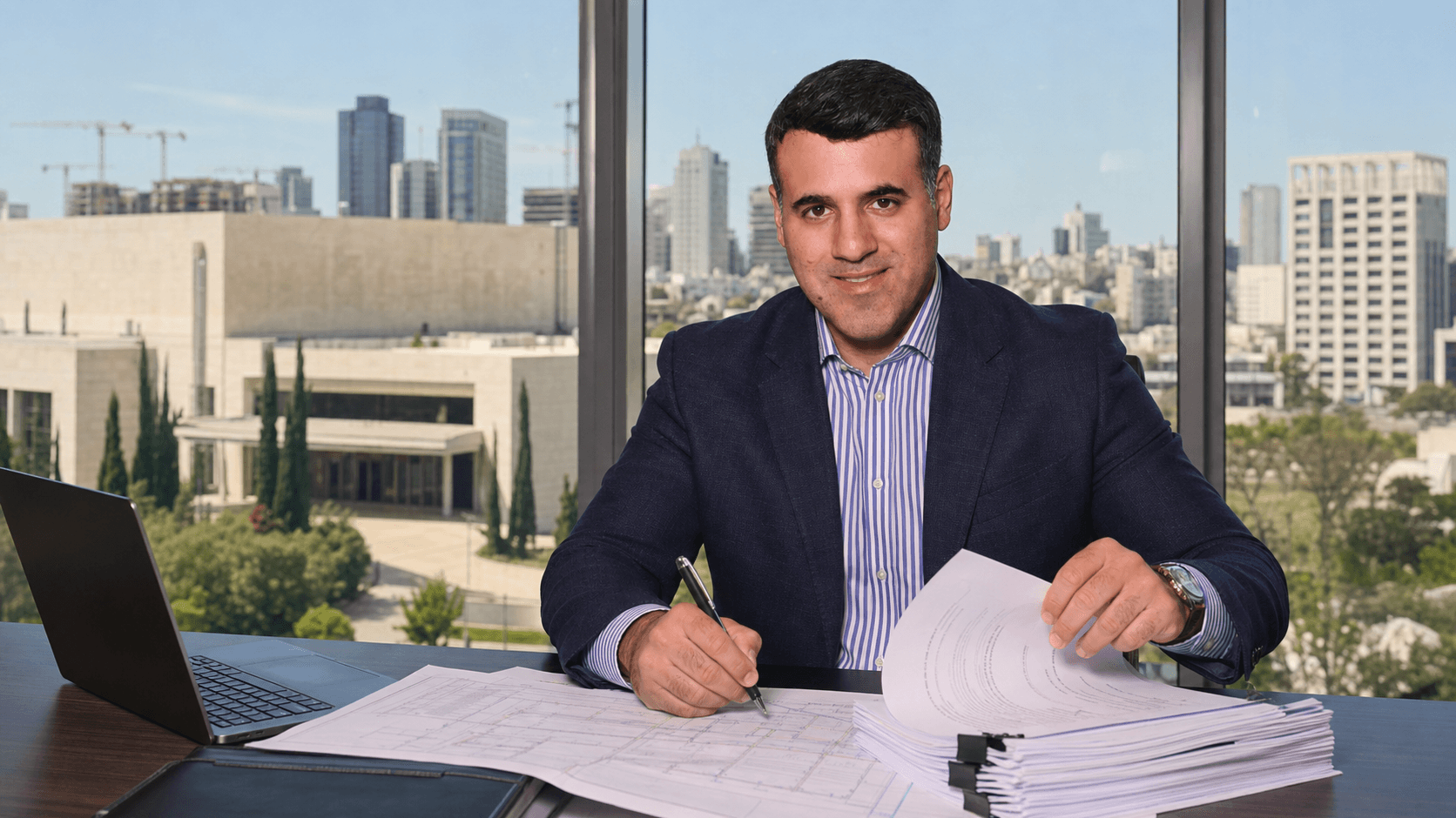 Asaf Arazi-Biton reviewing improvement levy legal documents after a Supreme Court ruling
