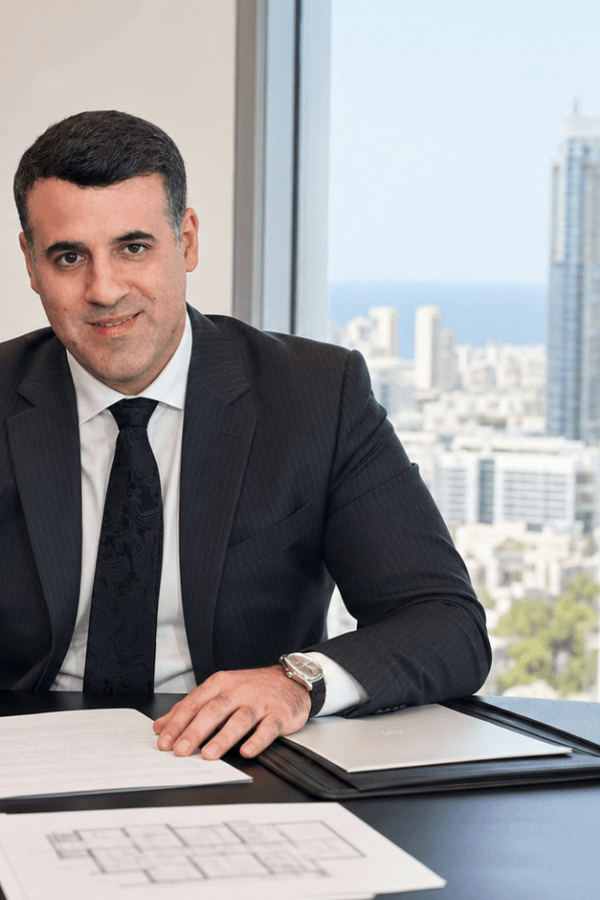 Asaf Arazi-Biton reviewing an apartment purchase agreement in a law office