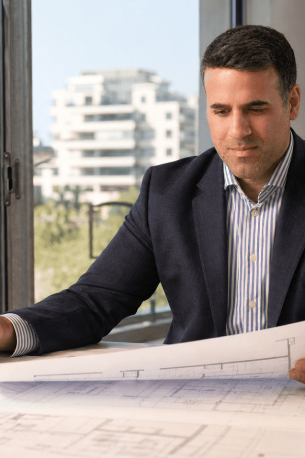 Asaf Arazi-Biton reviewing building plans and legal documents for an inherited apartment sale