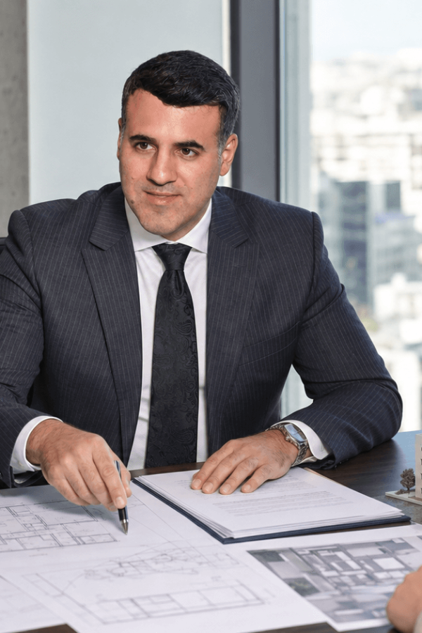 Asaf Arazi-Biton reviewing building plans and legal documents for an inherited apartment sale