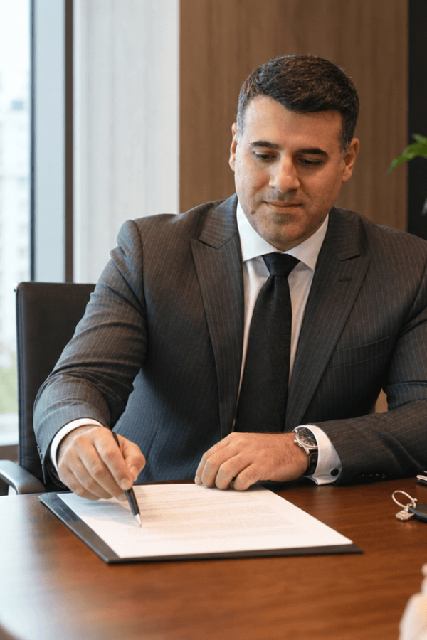 Asaf Arazi-Biton reviewing protective clauses in an apartment sale agreement with clients