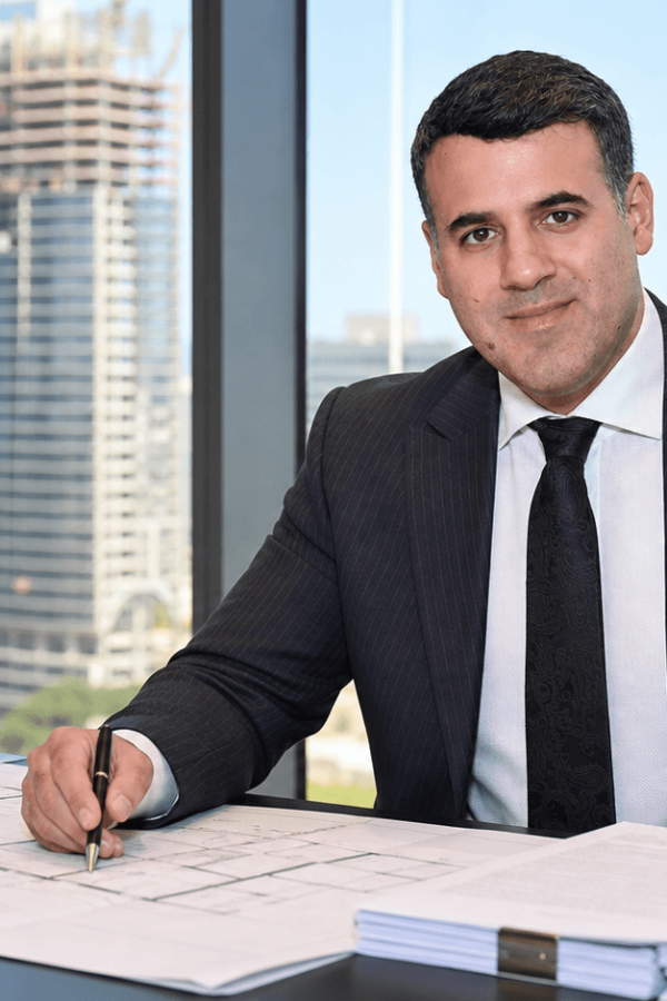 Asaf Arazi-Biton reviewing legal and planning documents for a real estate combination transaction